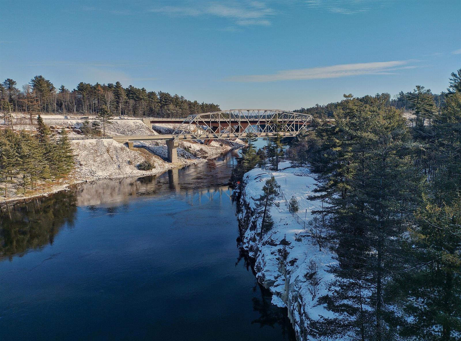 Forested banks and a bridge over the French River in Ontario