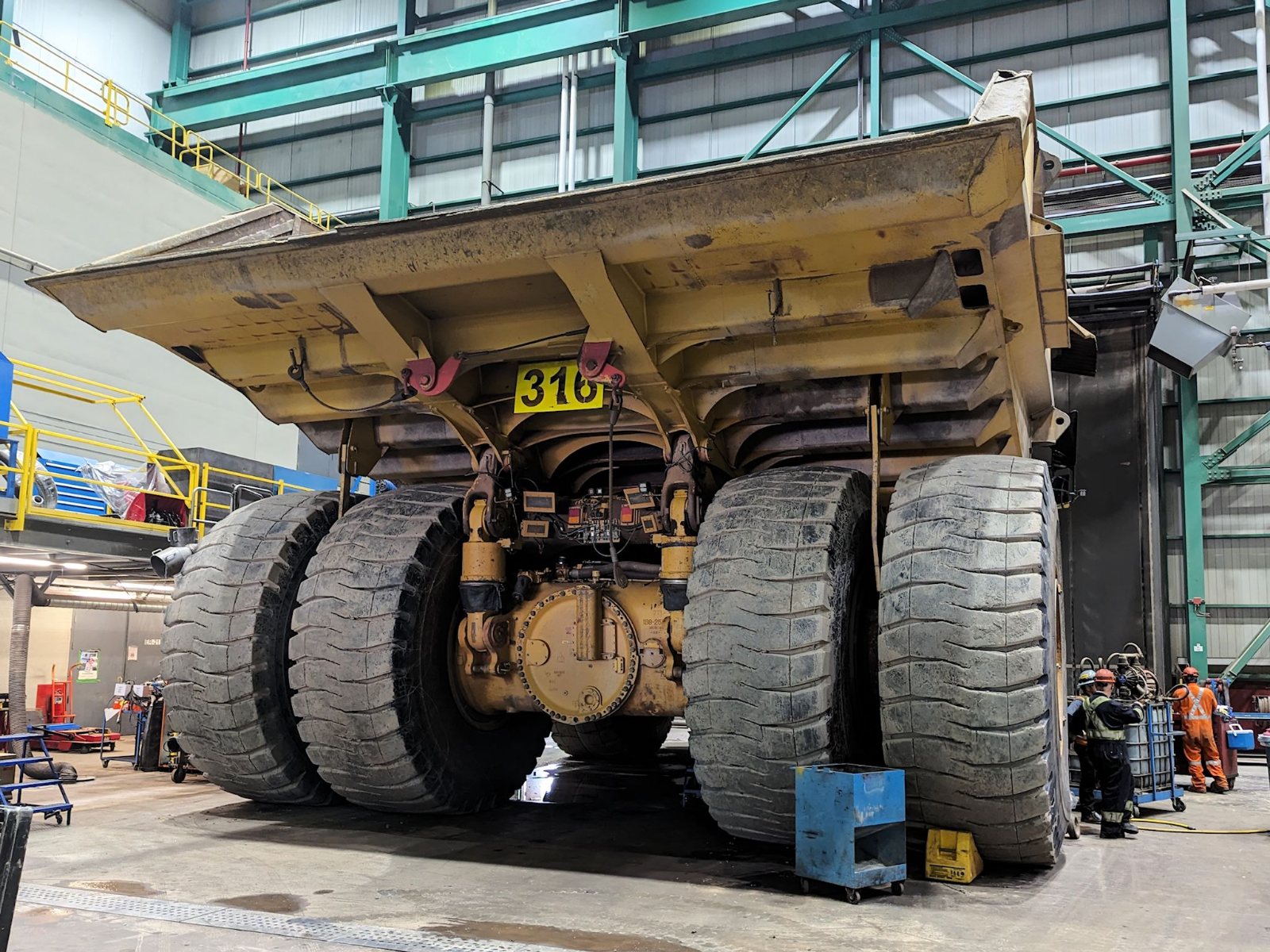 A giant haul truck being serviced by a maintenance crew at the Mont Wright mine in Quebec